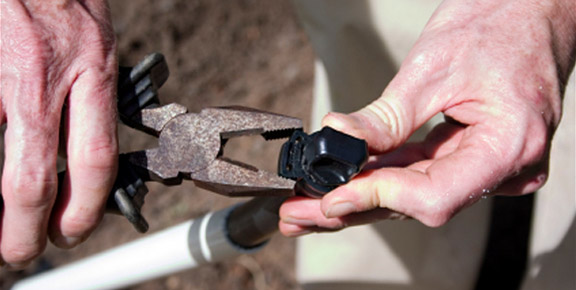 one of our techs is working on a sprinkler repair in Applewood, CO by adjusting a valve